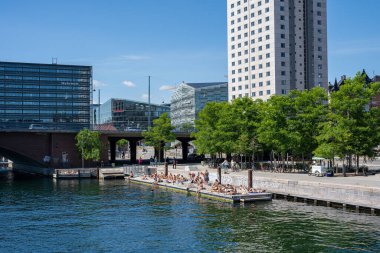 Kopenhag, Danimarka - 12 Temmuz 2022: İnsanlar limandaki Brygge Hristiyanları 'nda güneşleniyorlar