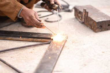 Çelik kaynaklama, kaynakçı çalışıyor. Çitin metal çerçevesinin kaynaklanması, yakın plan..