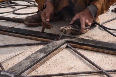 Çelik kaynaklama, kaynakçı çalışıyor. Çitin metal çerçevesinin kaynaklanması, yakın plan..