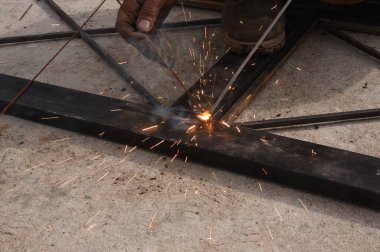 Çelik kaynaklama, kaynakçı çalışıyor. Çitin metal çerçevesinin kaynaklanması, yakın plan..
