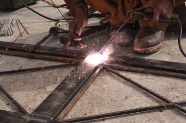 Çelik kaynaklama, kaynakçı çalışıyor. Çitin metal çerçevesinin kaynaklanması, yakın plan..