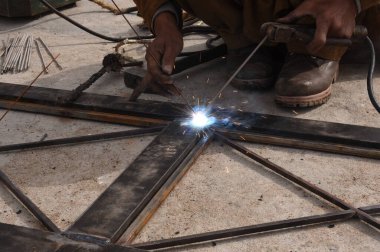 Çelik kaynaklama, kaynakçı çalışıyor. Çitin metal çerçevesinin kaynaklanması, yakın plan..