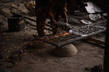 Çelik kaynaklama, kaynakçı çalışıyor. Çitin metal çerçevesinin kaynaklanması, yakın plan..