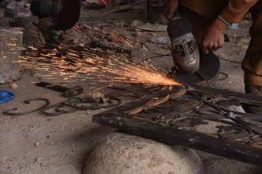 Çelik kaynaklama, kaynakçı çalışıyor. Çitin metal çerçevesinin kaynaklanması, yakın plan..