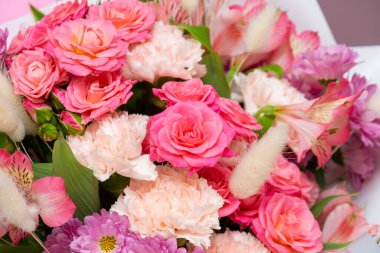light mixed bouquet of pink carnations, pink roses, alstroemeria, chrysanthemum, lagurus