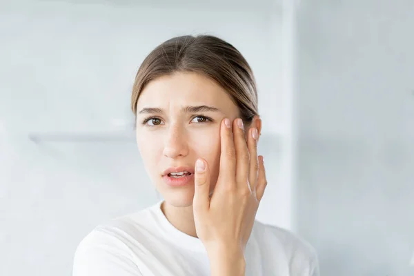 Occhio rughe pelle invecchiamento giovane donna toccare il viso — Foto Stock