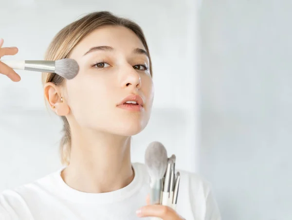 Trucco artista cosmetico applicando donna spazzola pelle — Foto Stock