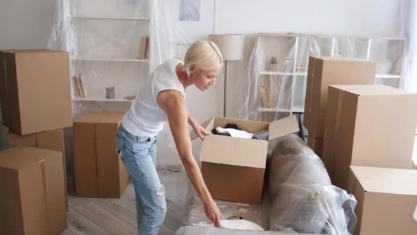 Relocatie stress gek volwassen vrouw verpakking spullen — Stockvideo