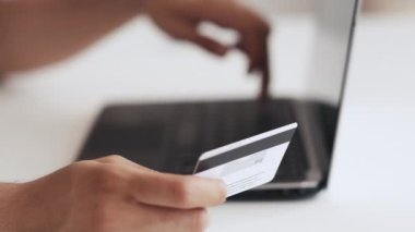 Online bankacı erkek elleri kredi kartı bilgisayarı kullanıyor