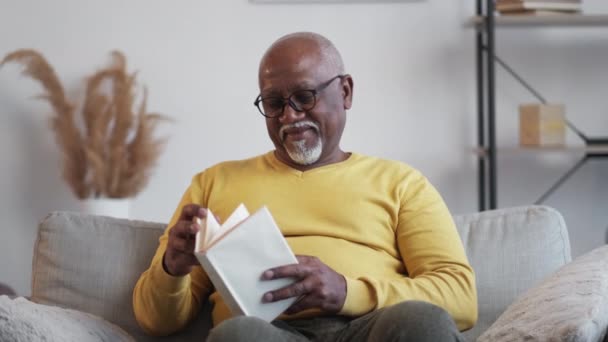 Dom wolny senior człowiek cieszący się czytanie — Wideo stockowe
