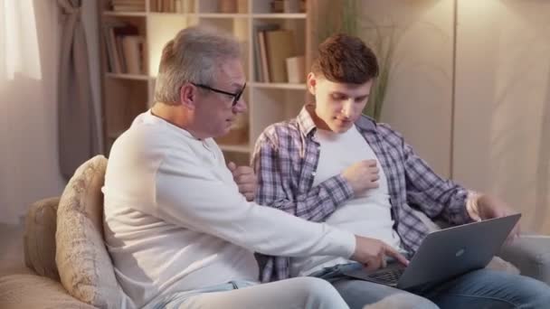 Pai ajudando filho laptop lazer casa pai sofá — Vídeo de Stock