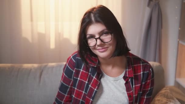 Счастливая женщина улыбается портрет студент диван домой — стоковое видео
