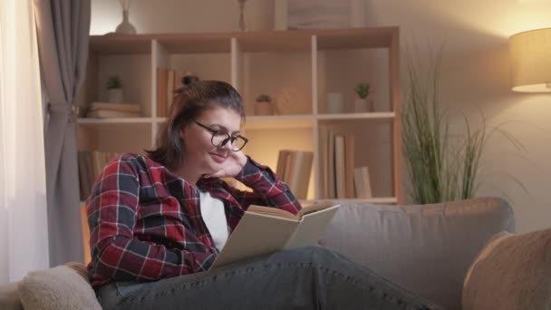 Затишне читання лінивих вихідних дозвілля жінка книга диван — стокове відео