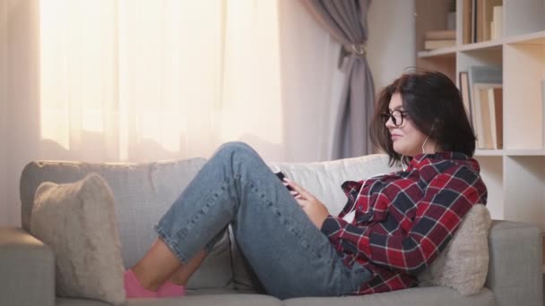 Мобильный досуг гаджет расслабляющий женщина телефон диван — стоковое видео