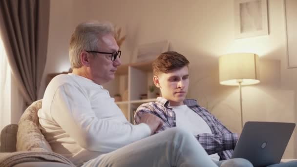 Обучение родителей семьи в помещении отец сын ноутбук — стоковое видео