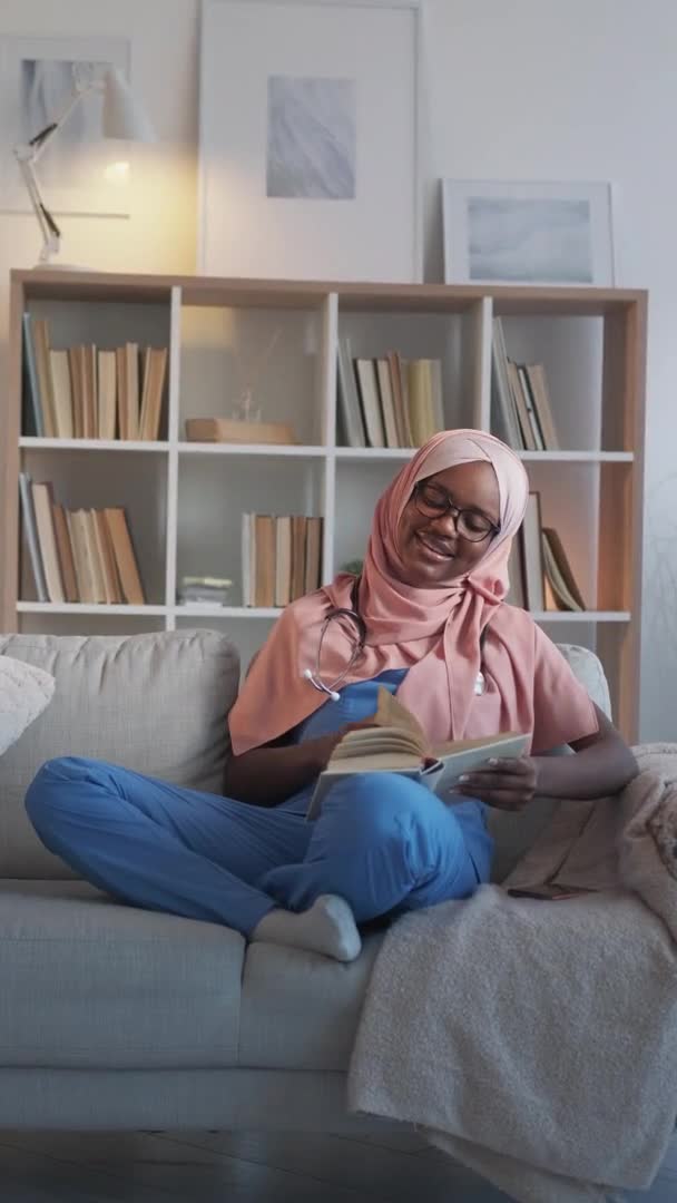 Интерн книга досуга женщина медсестра диван — стоковое видео
