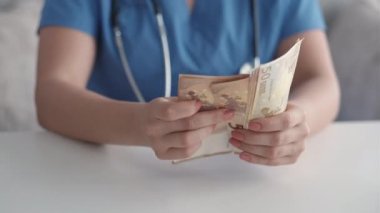 Sağlık sigortası doktoru nakit para sayıyor.
