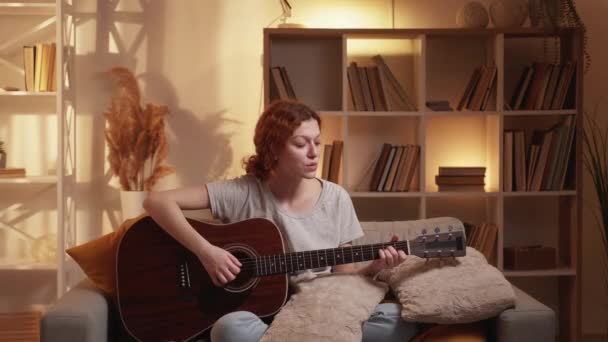 Гітара грає музиканта дозвілля жінка диван додому — стокове відео