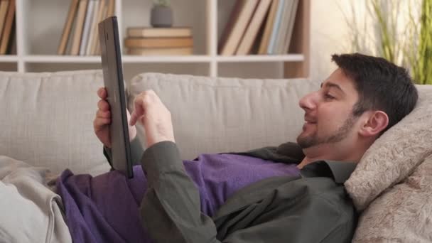 Συσκευή χαλαρωτικό internet διασκέδαση σπίτι Σαββατοκύριακο άνθρωπος καναπέ — Αρχείο Βίντεο