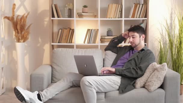 Uykulu adam internet bağımlısı dizüstü bilgisayar kanepesi — Stok video
