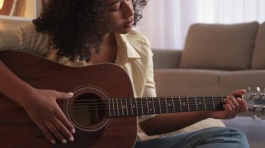 Müzik alıştırması yapan gitar çalan kadın akorlarını evde yapıyor.