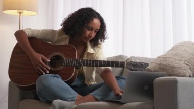 Online gitar dersi müzik eğitimi alan kadın dizüstü bilgisayar