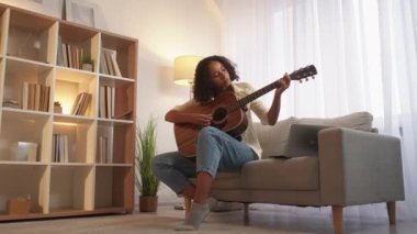 Gitar çalmayı öğrenen bir kadın müzisyen.
