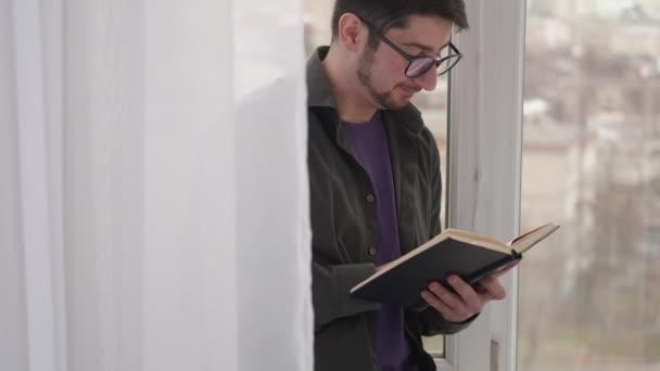 Lezen recreatie huis recreatie man boek venster — Stockvideo