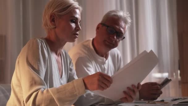 Financiële uitgaven facturen van echtparen van middelbare leeftijd — Stockvideo