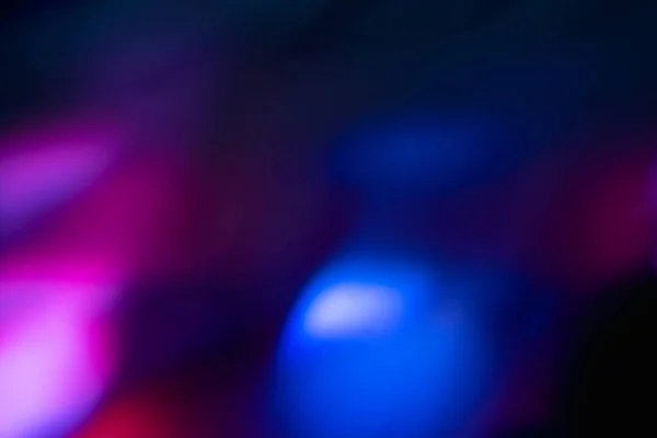 Rozmazaný neonový světelný objektiv světlice překrývající modrou fialovou — Stock fotografie