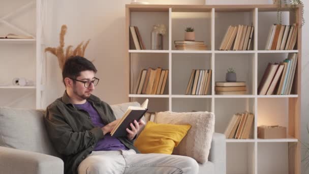 Házi olvasmány könyv szabadidő otthon pihentető férfi — Stock videók