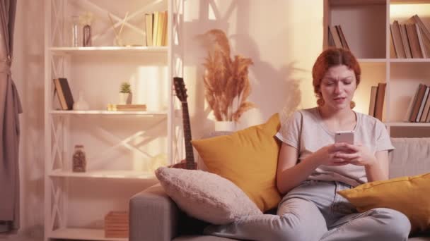Kötü uygulama çevrimiçi hüsran kadın telefon kanepede ev — Stok video