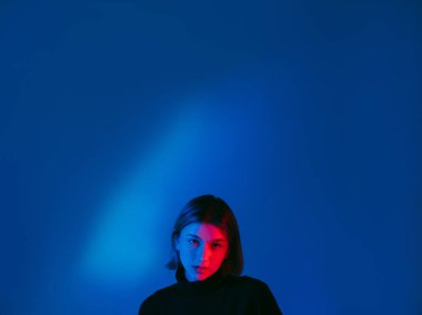 Neon ışıklı yüz reklamı. Arka planda mavi kadın.