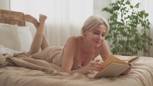 Интересный роман чтение женщина наслаждается отдыхом — стоковое видео