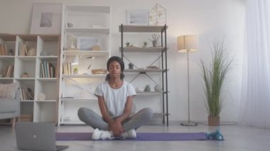 Evde meditasyon yapan yoga yapan kadın Lotus 'u rahatlatıyor.