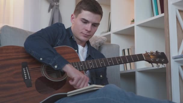 Музичне написання гітарного хобі чоловік складає пісню додому — стокове відео