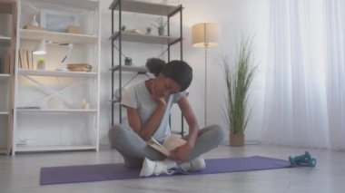 Fitness kitabı okumak boş zamanlarında evde öğrenen kadınlar.