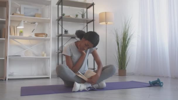 Фітнес книга читання дозвілля жінка вчиться вдома — стокове відео
