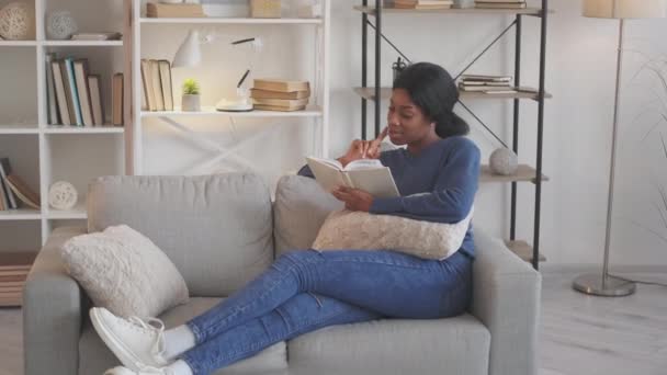 Boek vrijetijdsbesteding lezen hobby huis vrouw roman bank — Stockvideo