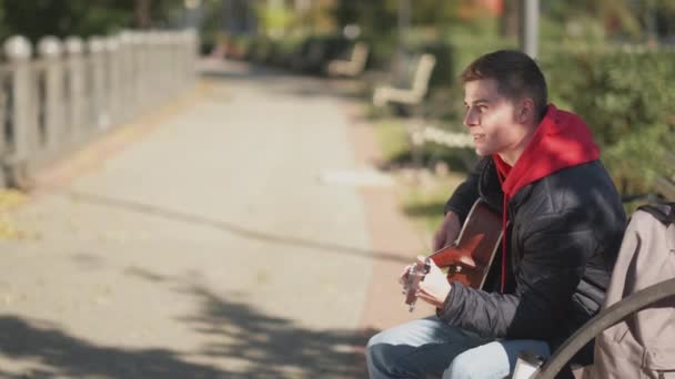 Strada chitarrista musicista stile di vita uomo panchina parco — Video Stock