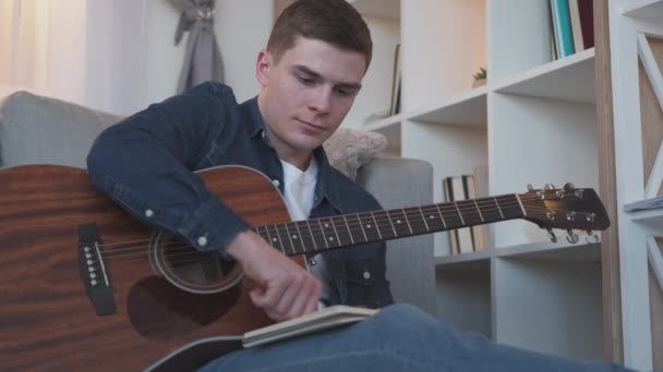 Music writing guitar hobby man composing song home — Stock Video