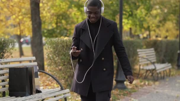 Auriculares música divertida escuchar hombre bailando parque — Vídeo de stock