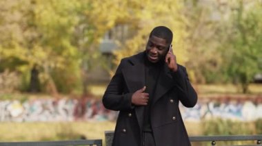 Dışarıda cep telefonuyla konuşuyor. Autumn Caddesi 'ndeki adamı arıyor.