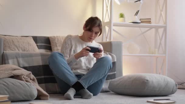 Телефон видео игры гаджет развлечения женщина дома — стоковое видео
