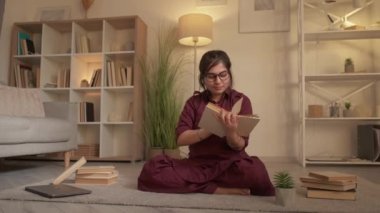 Akşam kitap okuma aşığı kadın öğrenci evinde.