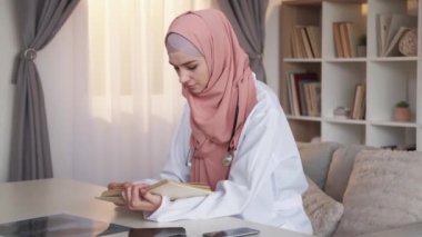 Doktor eğitimli tıp öğrencisi kadın kitap okuyor.