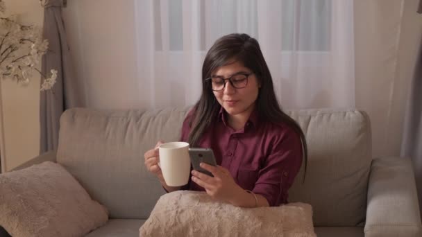 Kawa relaks telefon rozrywka dom kobieta kanapa — Wideo stockowe