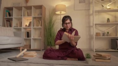 Akşam kitap okuma aşığı kadın öğrenci evinde.