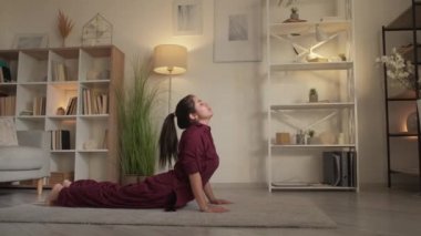 Yoga eğitmeni, spor salonundaki kadın kobra pozu veriyor.