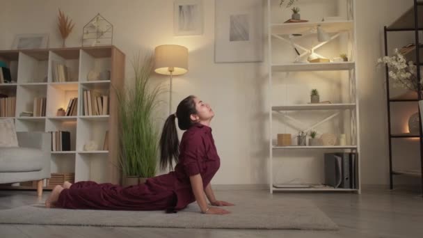 Yogaträning hem gym kvinna utövar kobra pose — Stockvideo